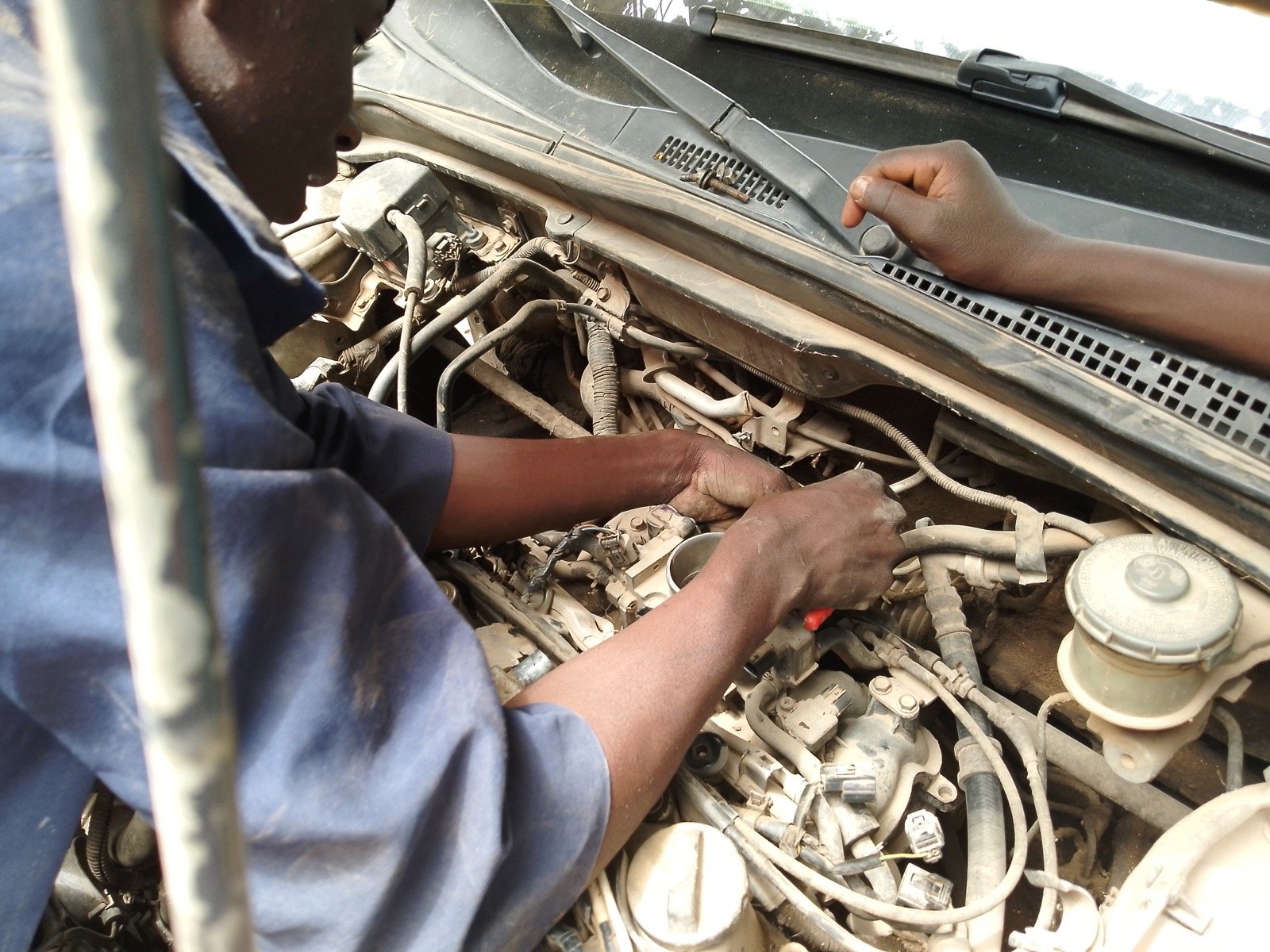 Mechanic repairing a car engine with hand tools